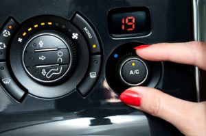 Mano encendiendo el aire acondicionado del coche