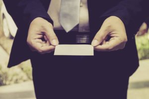 Señor trajeando sujetando tarjeta de visita en blanco