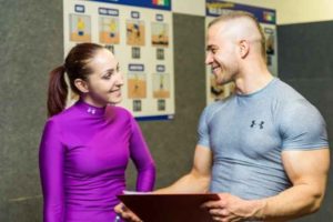 chico asesorando a chica en gimnasio