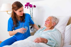 Sanitaria atendiendo a persona mayor con Alzheimer