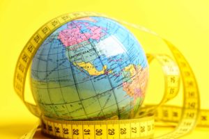 Bola del mundo de plástico rodeada de cinta de medir