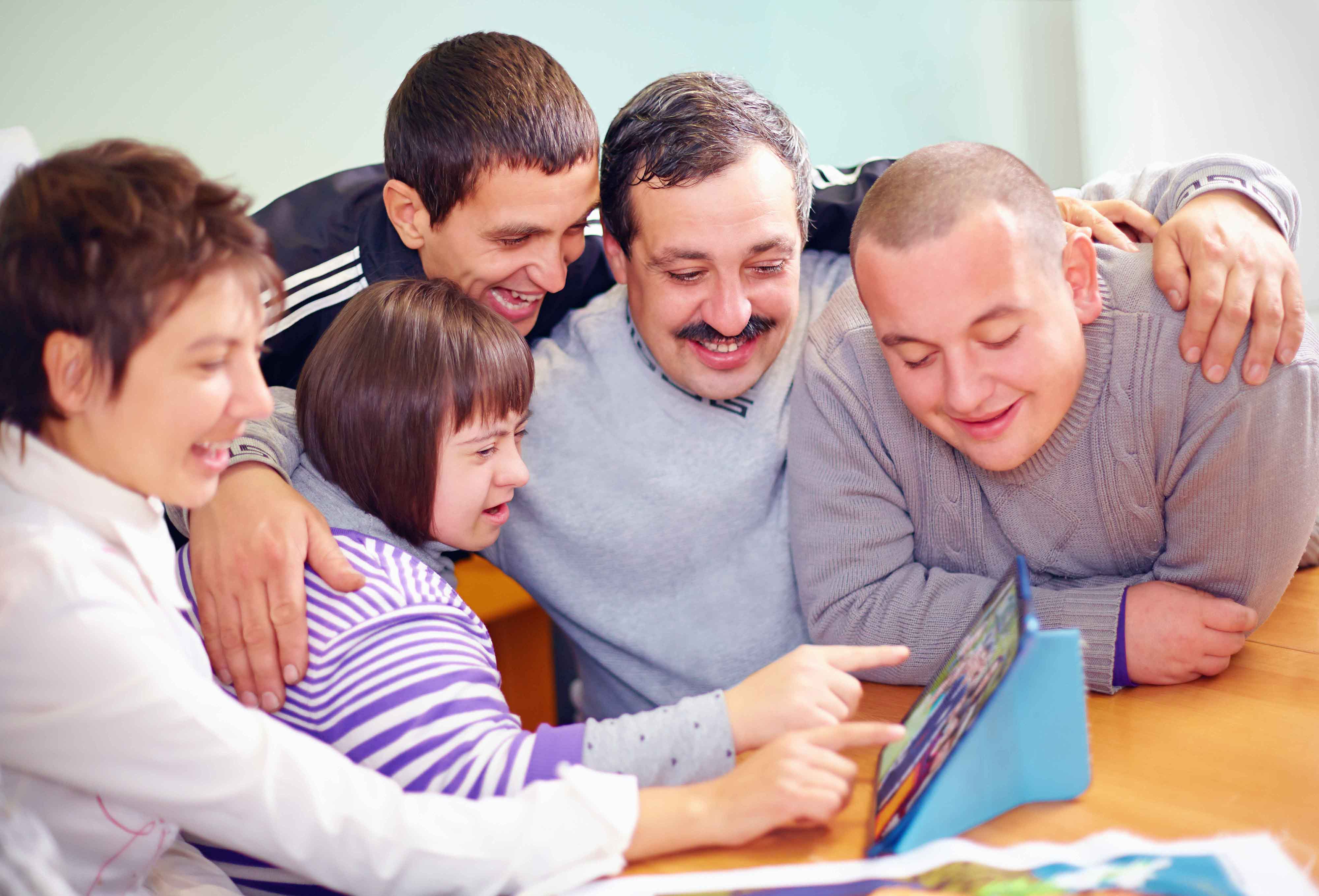 Chicos y chias con discapacidad psíquica mirando algo en una tablet
