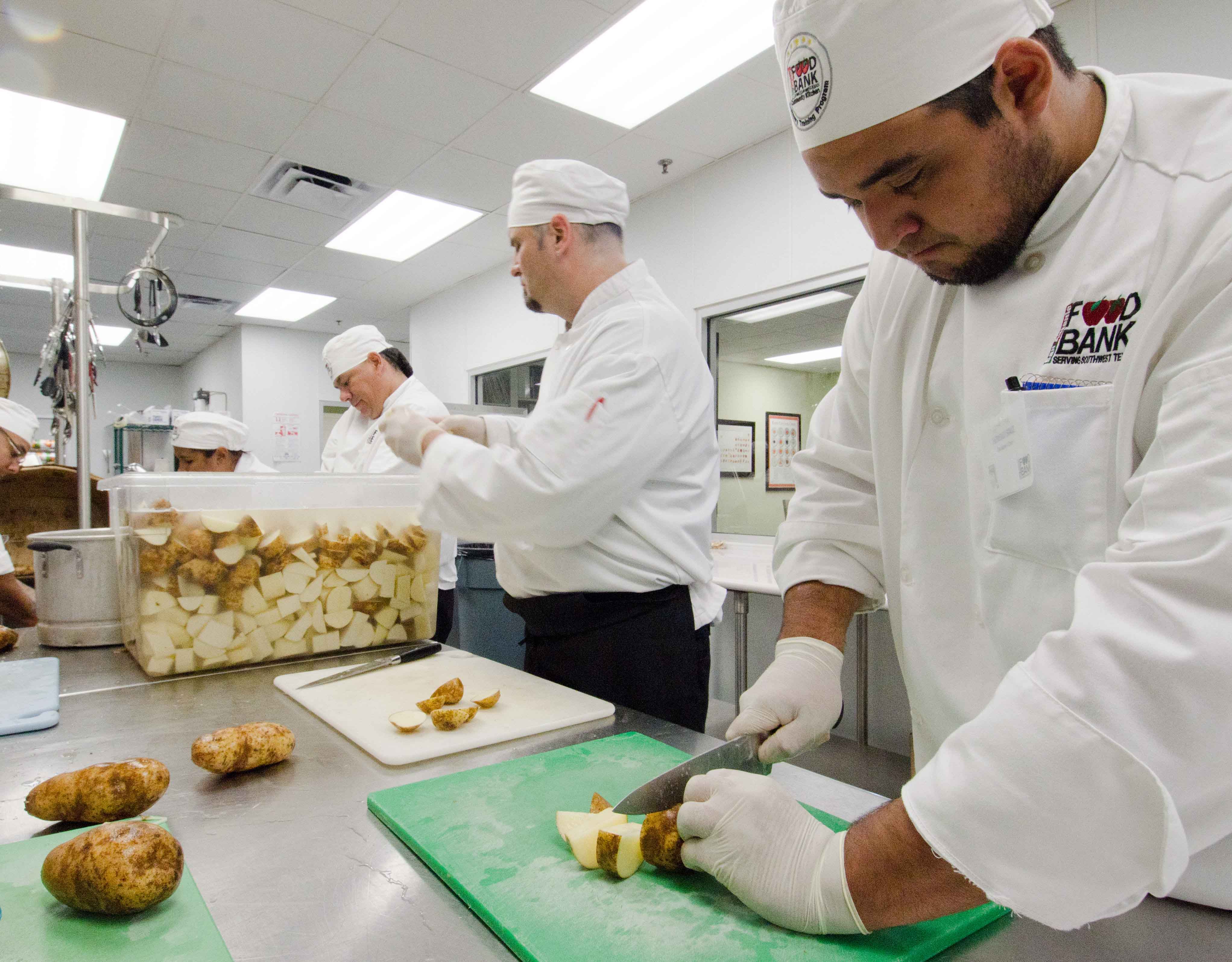 Trabajadores pelando patatas en cocina industrial
