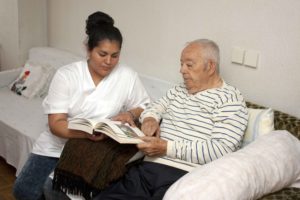 Chica ayudando a leer una revista a anciano