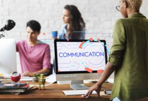 Trabajadores de empresa y pantalla de ordenador que pone "comunicación"