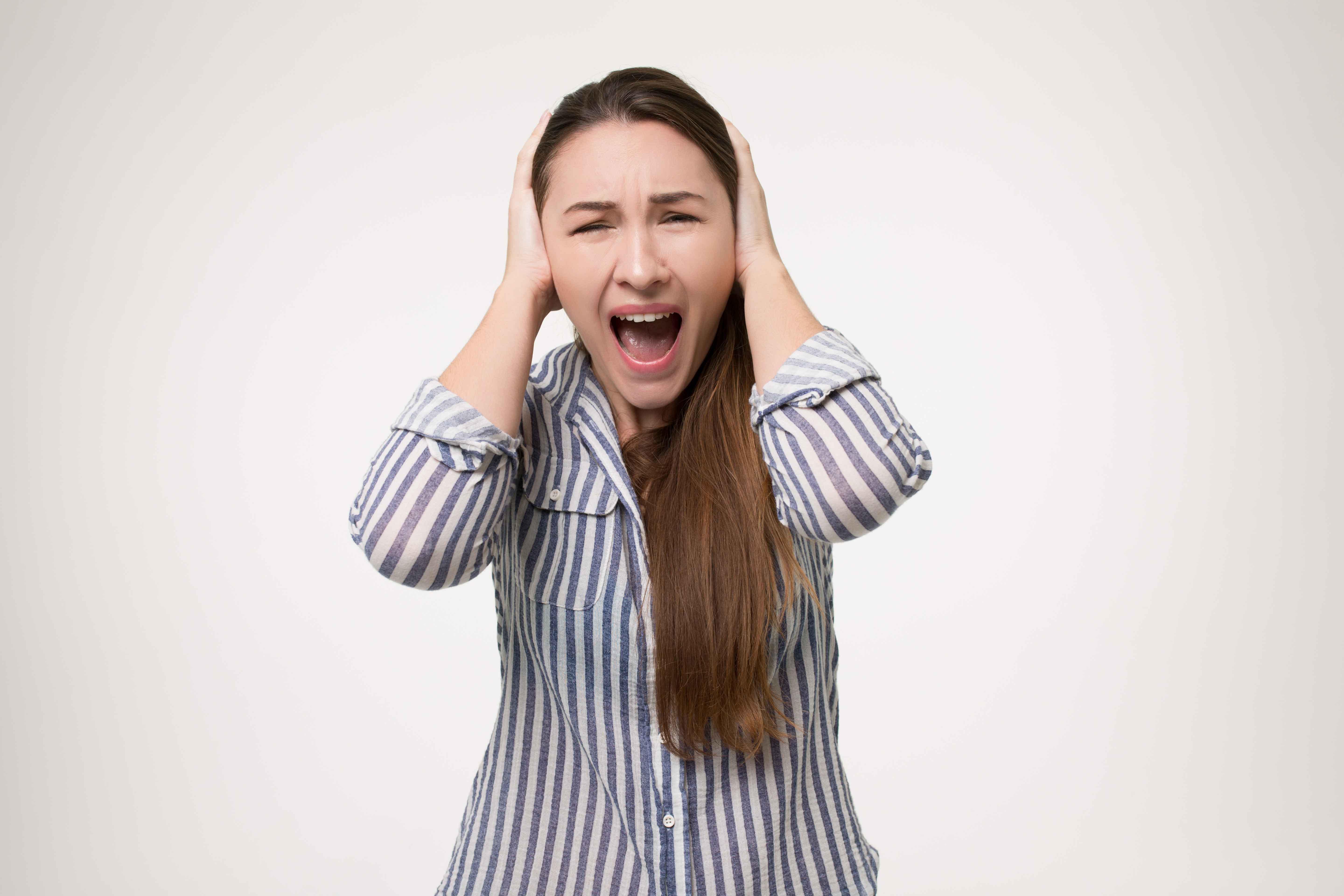 Chica gritando y tapándose los oídos
