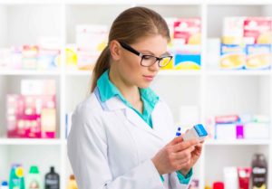 Farmaceutica mirando medicamento