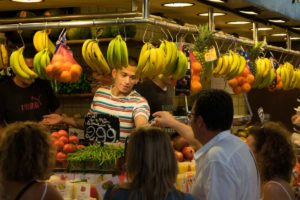 Chico cobrando en puesto de frutería