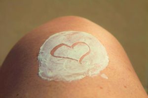 Corazón dibujado en la piel con crema