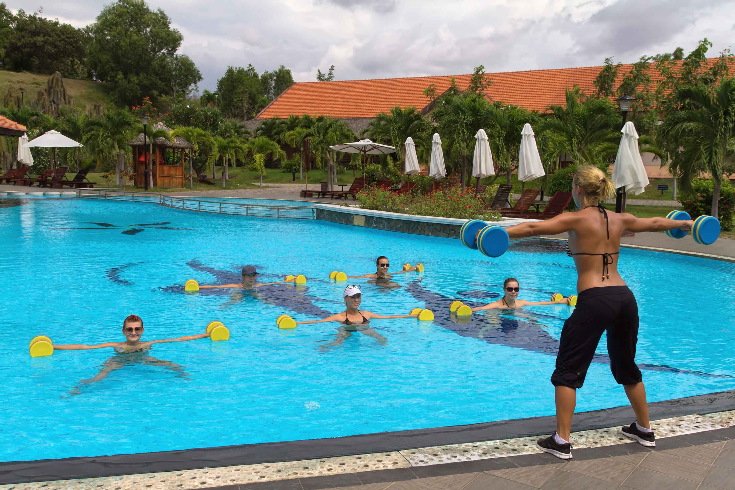Chica dirigiendo coreografía desde fuera de la piscina