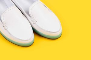Zapatos blancos sobre fondo amarillo