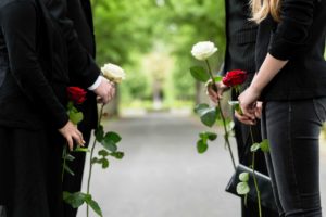 Familia de luto con rosas en la mano