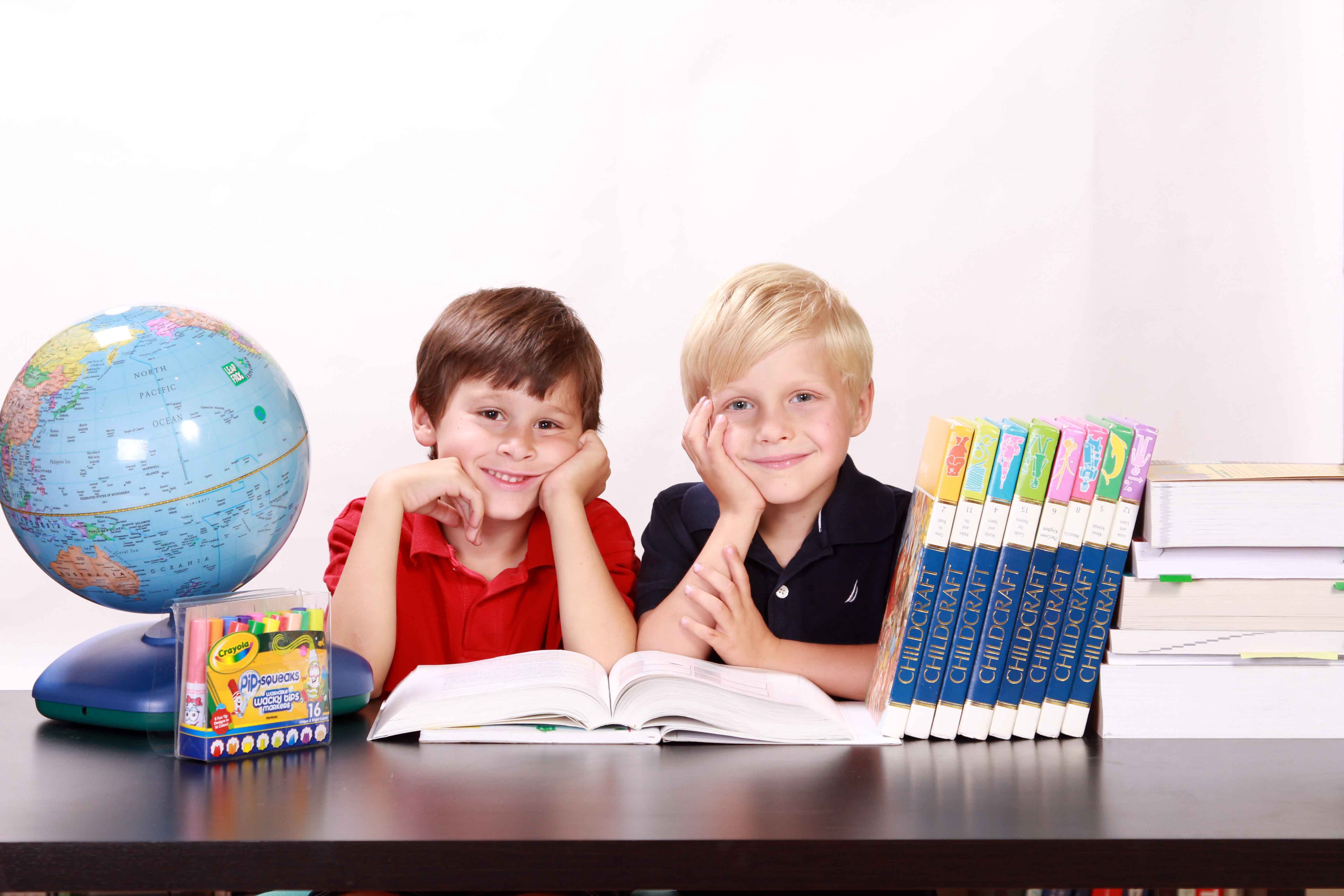 Dos niños sonrientes entre elementos escolares