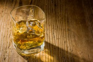 Vaso de whisky sobre mesa de madera