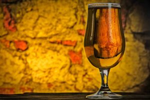 Copa de cerveza sobre fondo amarillento