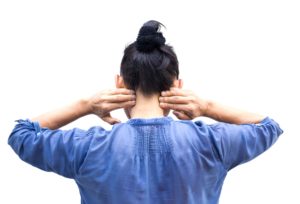 chica de espaldas tocándose cuello con dolor