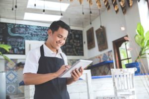 Chico con tablet en pastelería