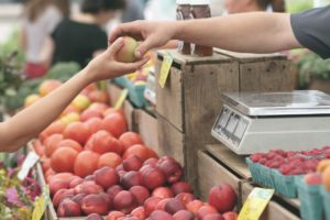 Dependiente atendiendo en puesto de frutería