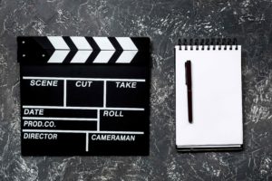 Claqueta de cine y libreta en blanco al lado
