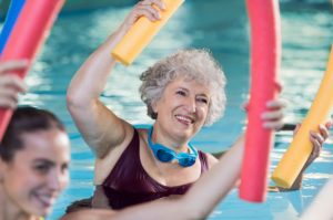 Señora mayor haciendo actividades en una piscina