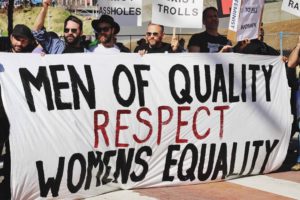 Manifestación de hombres portando pancarta con el texto "Los hombres de calidad respetan a las mujeres en igualdad"