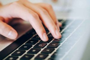 Manos sobre teclado de portátil