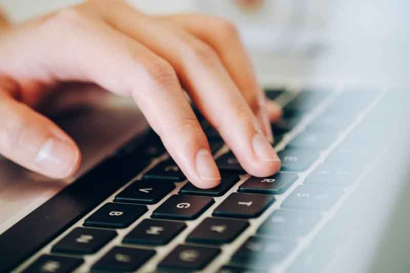 Manos sobre teclado de portátil