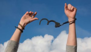 Manos liberándose de esposas en el aire