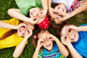 Niños tumbados en círculo sobre el césped