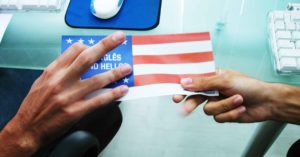 Mano entregando a otra bandera de USA