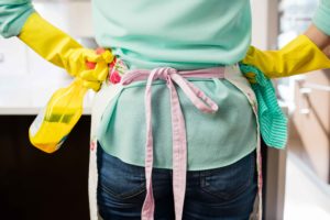 Mujer dispuesta para limpiar con productos en las manos
