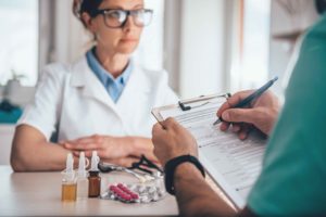 Farmacéuticos junto a botes de medicamentos líquidos