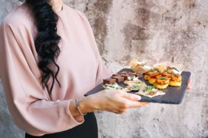 Chica portando bandeja con comidas