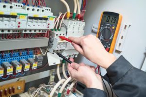 Persona trabajando en cuadro eléctrico