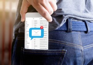 Móvil sacándose de bolsillo con notificación de nuevo mensaje