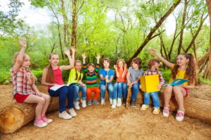 Chicos leyendo en un campamento al aire libre