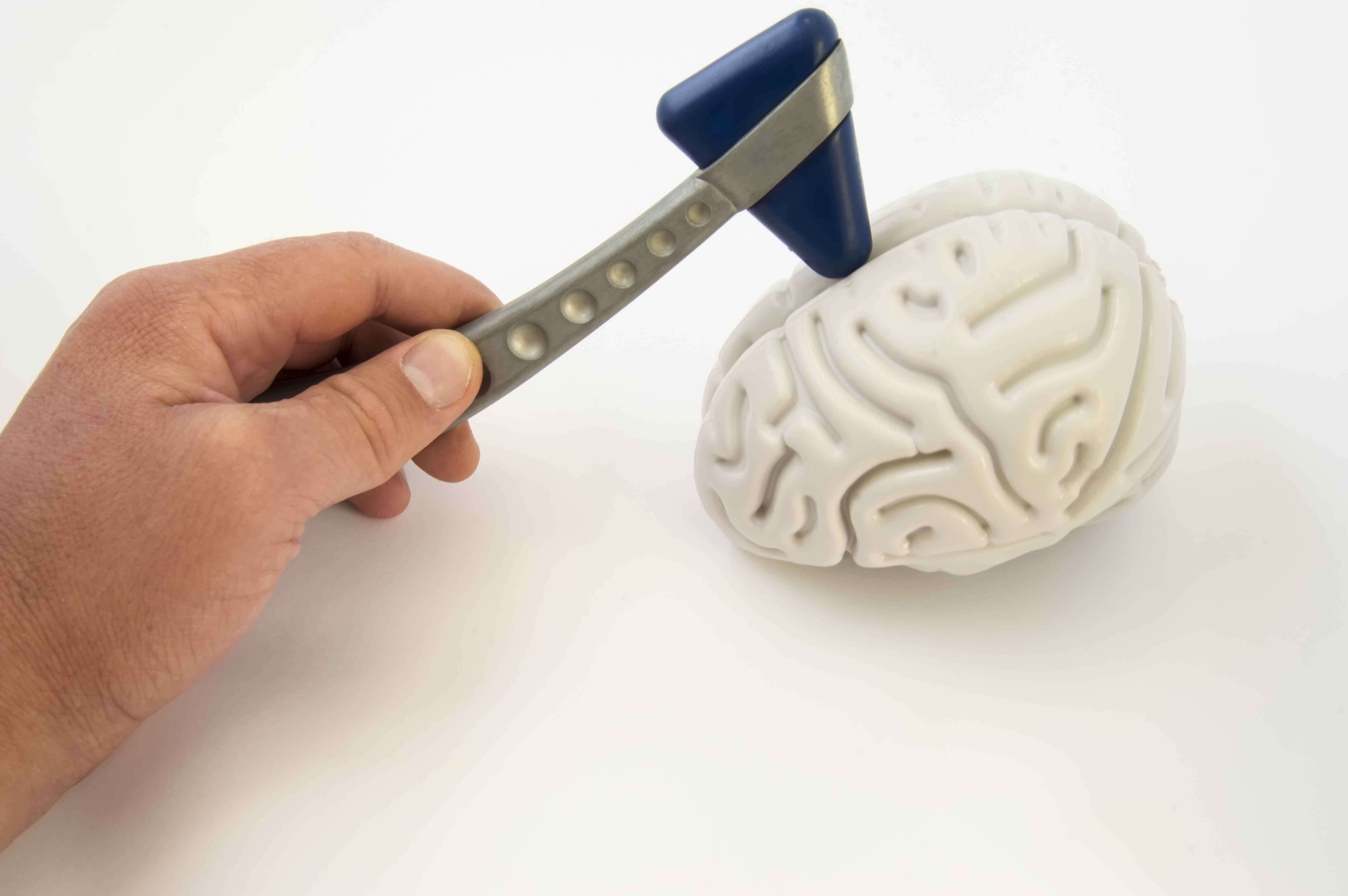 Cerebro artificial con doctor tocándolo con herramientas quirúrgicas