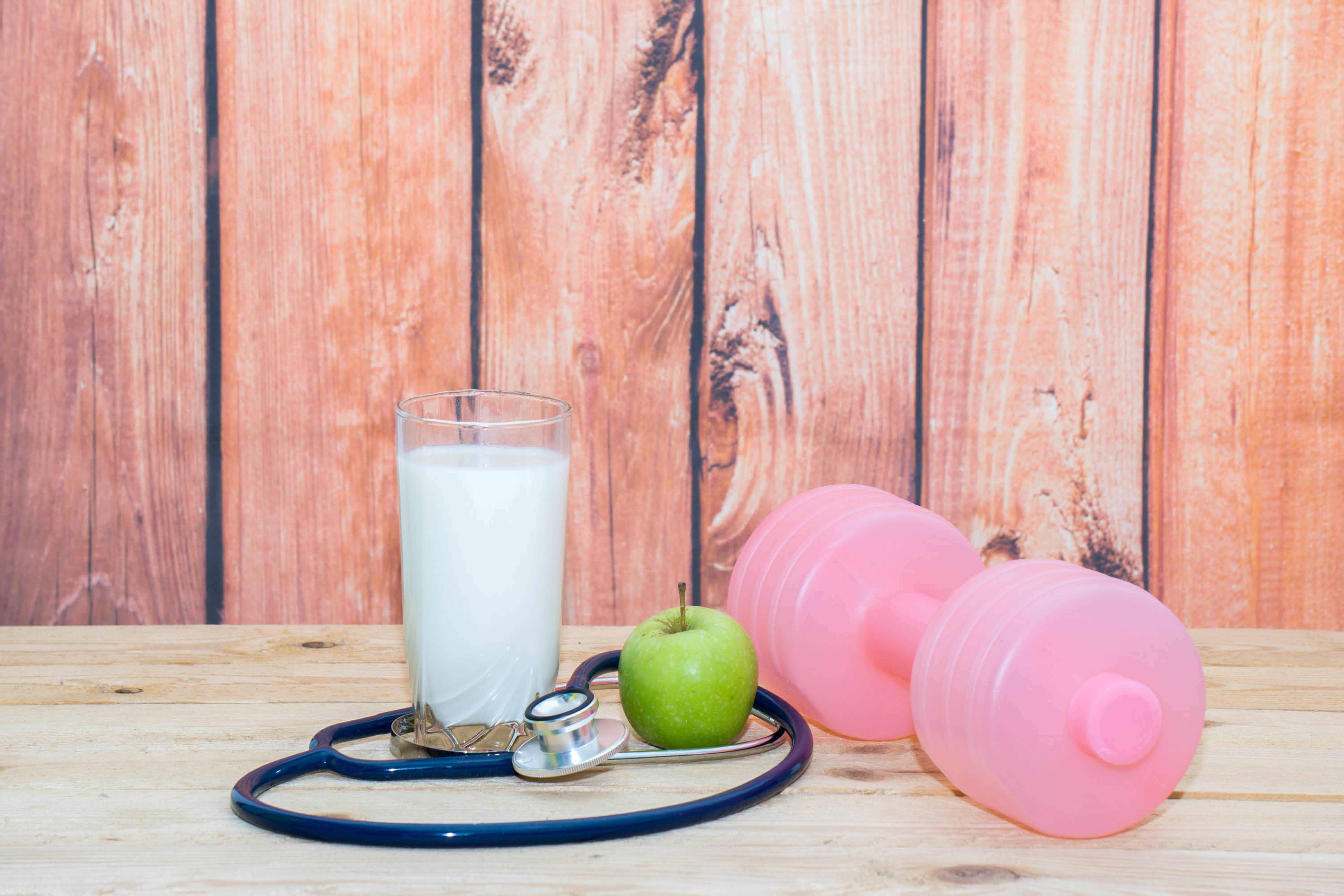 Mancuerna al lado de fruta y comida saludable