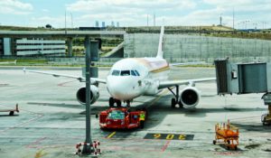 Avión en aeropuerto y trabajadora de pista cerca