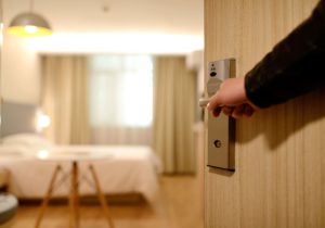 Mano abriendo puerta de habitación de hotel