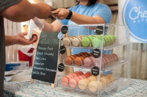 Dependienta cobrando a cliente en mostrador de pastelería