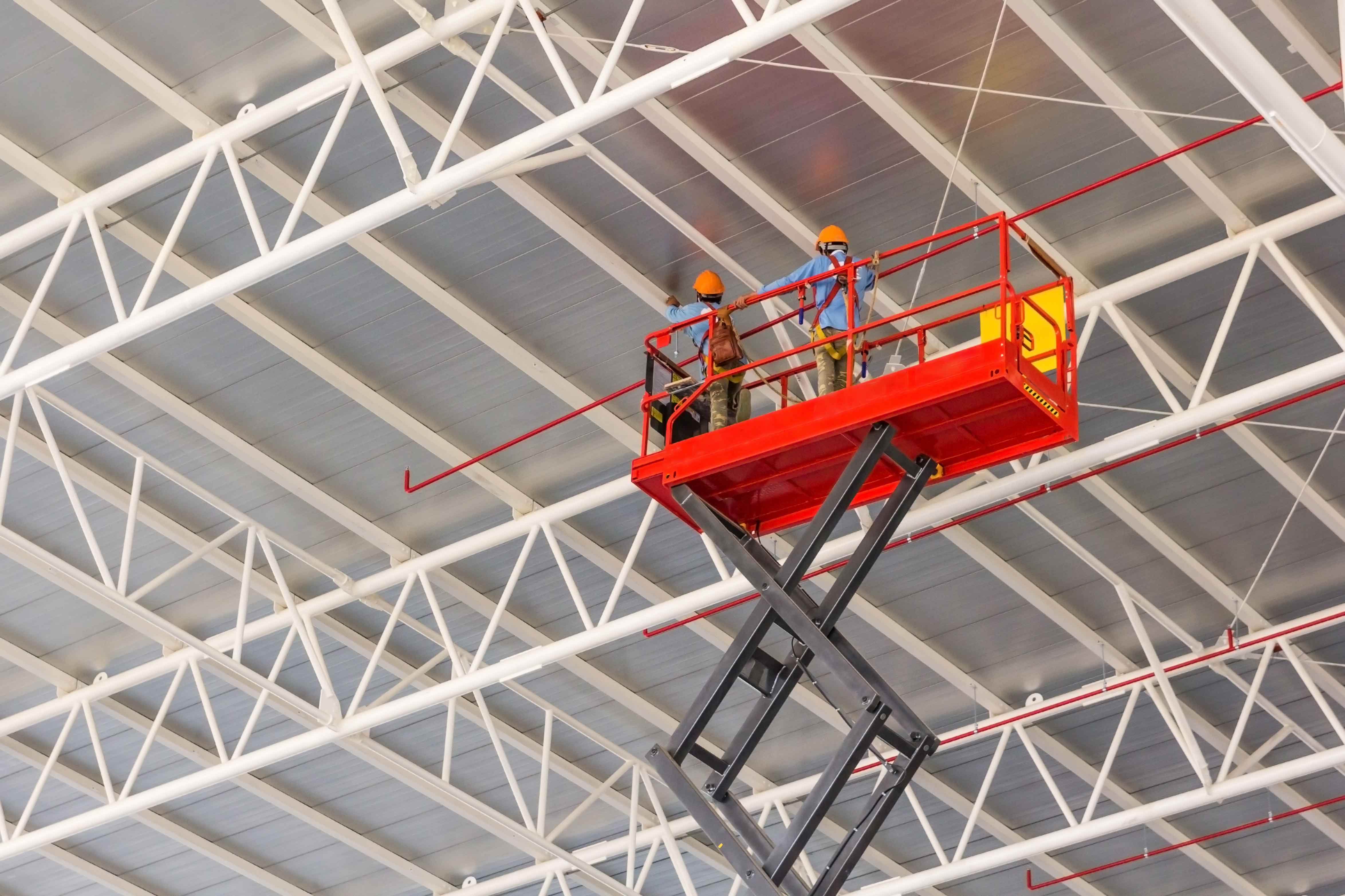 Dos obrreros trabajando en plataforma elevadora