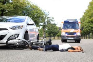 Ambulancia llegando a lugar de accidente con mujertendida en el suelo