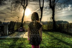 Niña de espaldas en paisaje siniestro