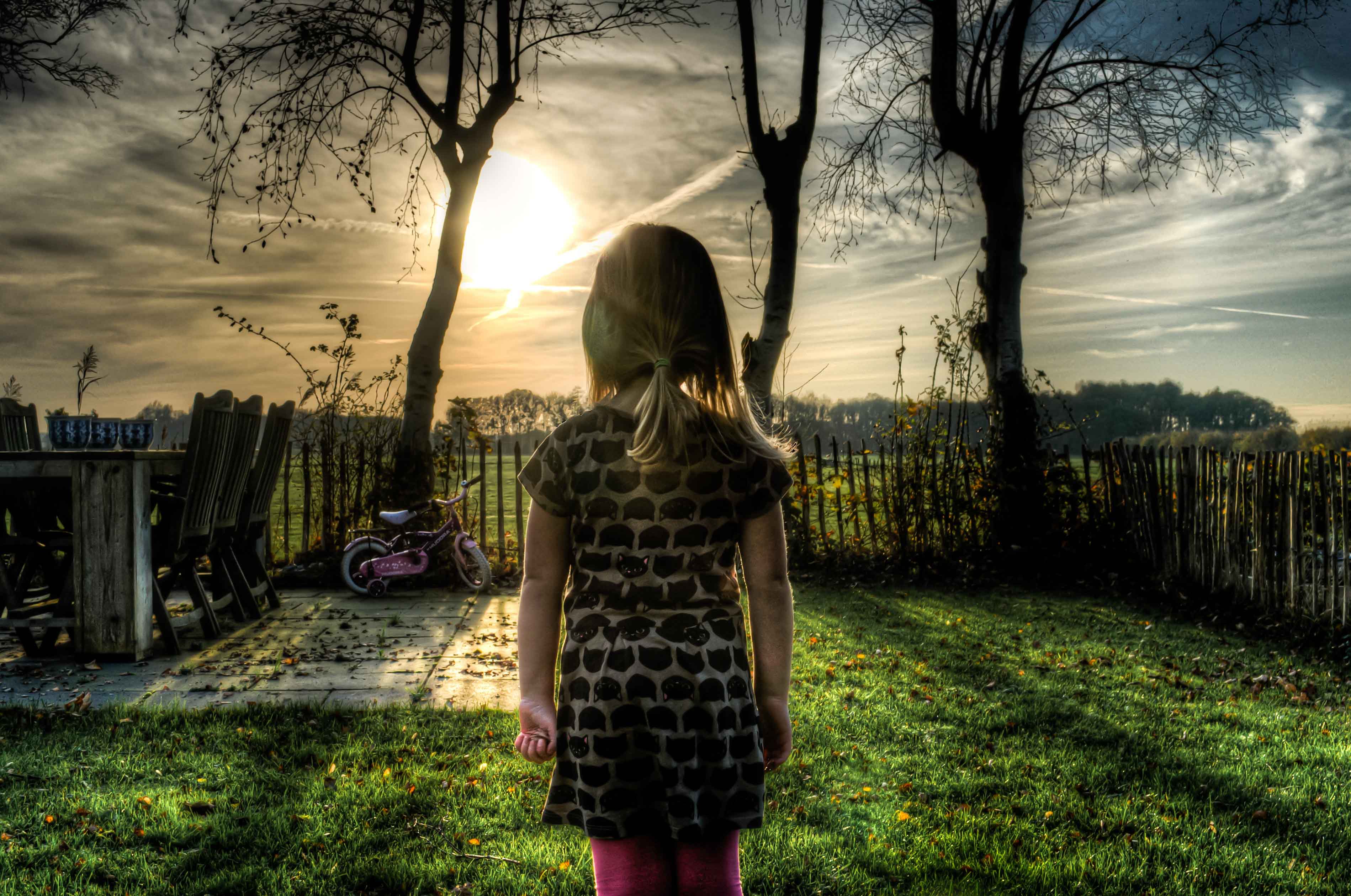 Niña de espaldas en paisaje siniestro