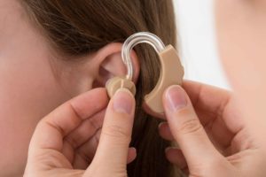 Chica poniéndose prótesis en oreja