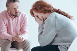 Chica con gesto preocupado hablando con terapeuta