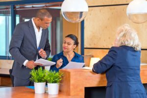 Dos recepcionistas en mostrador de hotel