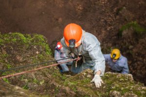 Rescatador descendiendo por barranco con arnés