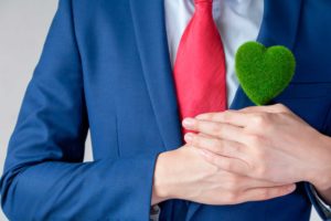Ejecutivo sujetando corazón hecho con césped